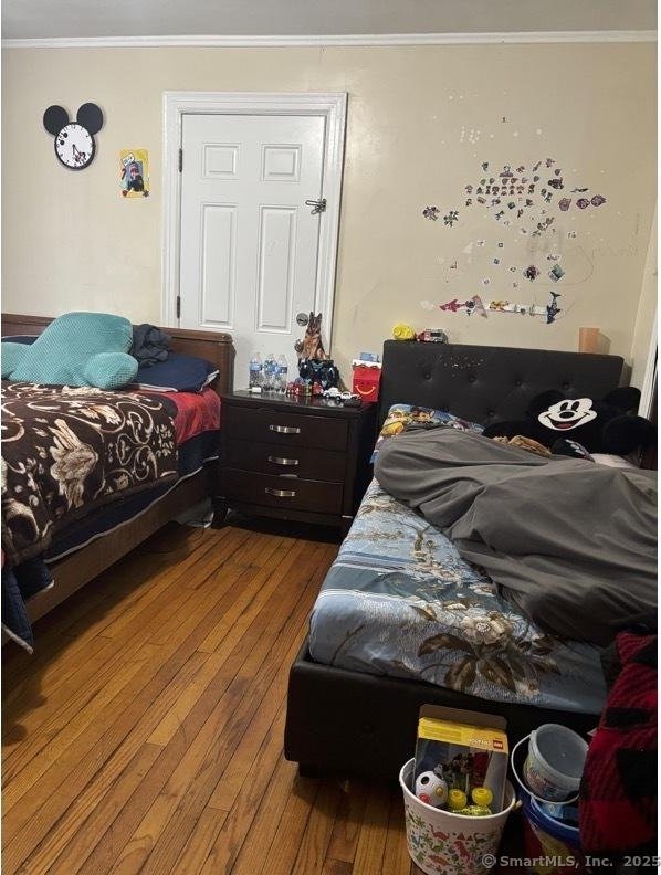 bedroom featuring ornamental molding and hardwood / wood-style flooring