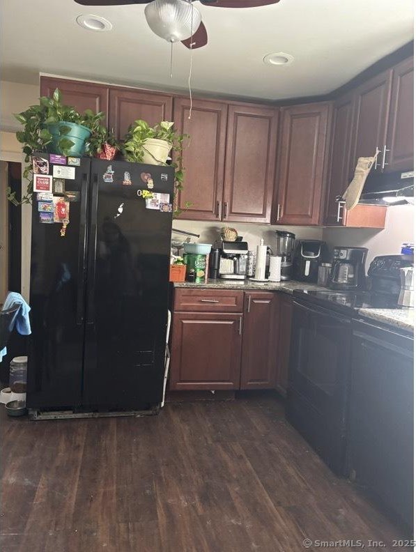 kitchen with black appliances, extractor fan, dark wood-type flooring, and ceiling fan