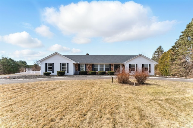 ranch-style home featuring brick siding and a front yard