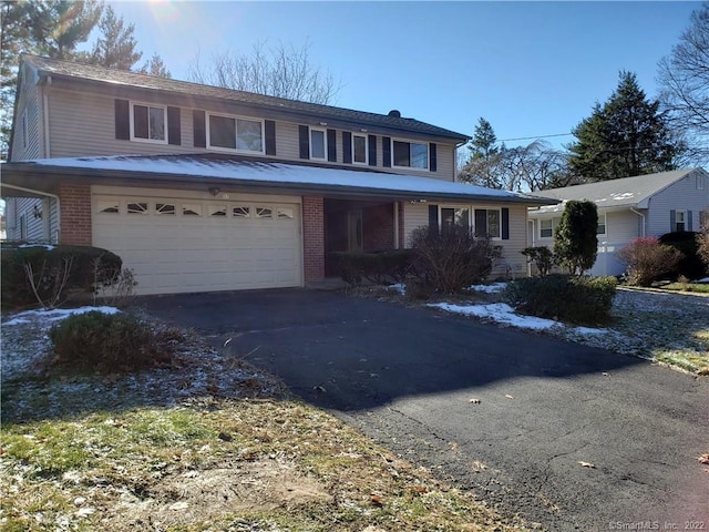 traditional-style home with a garage, brick siding, and driveway