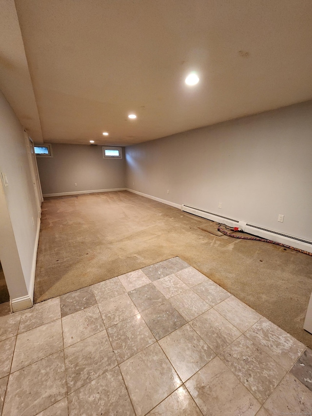 below grade area featuring carpet flooring, recessed lighting, baseboards, and a baseboard radiator