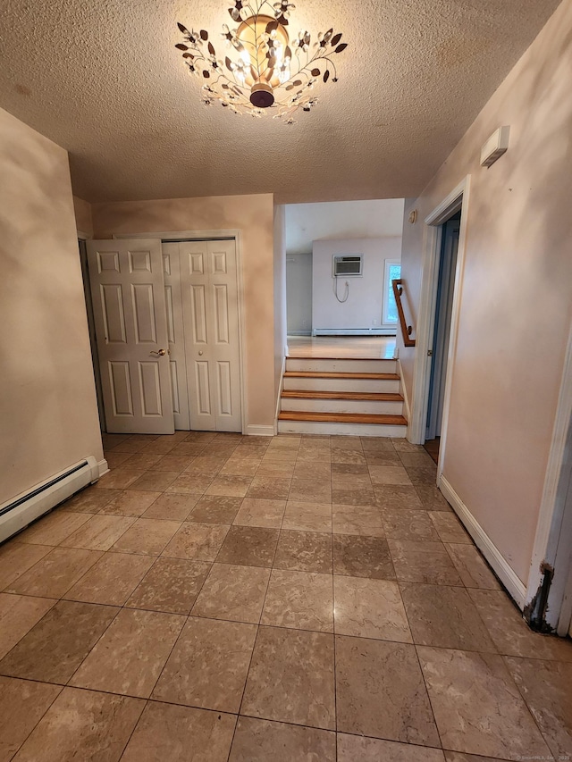 hallway with stairway, a textured ceiling, a baseboard heating unit, and baseboards