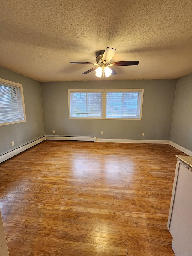 spare room with a wealth of natural light, baseboards, and wood finished floors