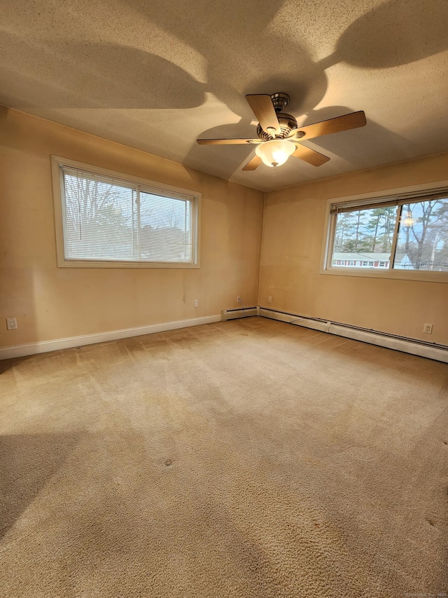 empty room with a textured ceiling, a ceiling fan, baseboards, and carpet floors