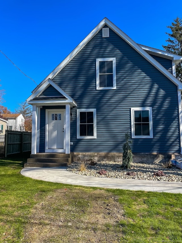 view of front of home with a front yard and fence