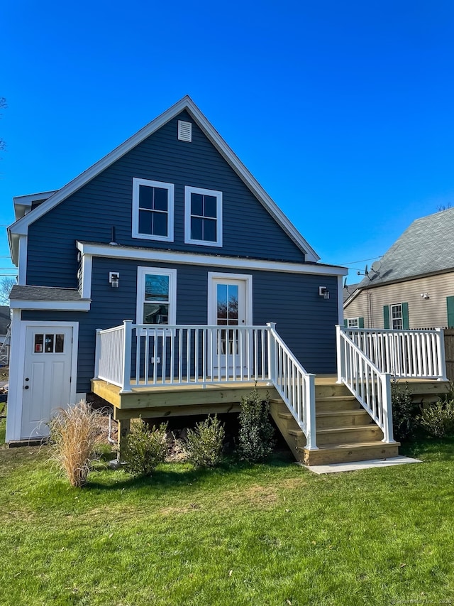 back of property with a deck and a yard