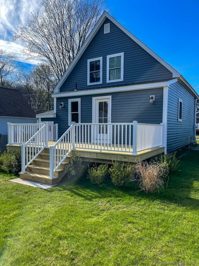 rear view of property featuring a yard and a wooden deck