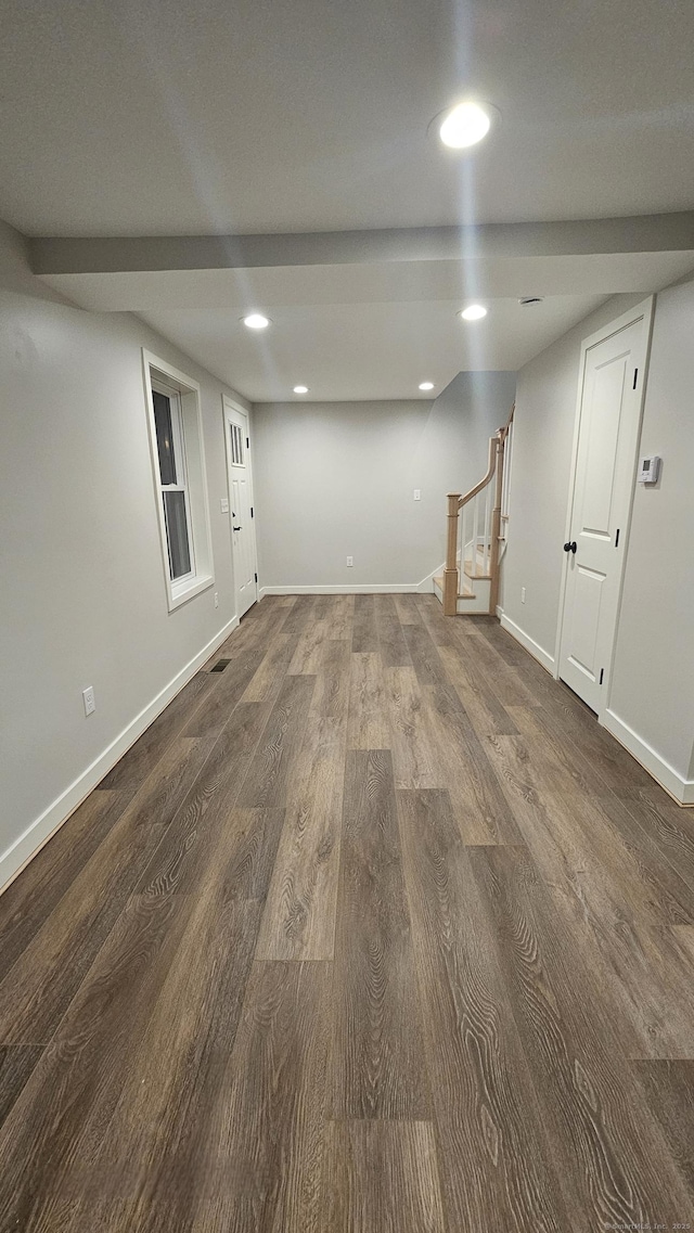 finished below grade area featuring recessed lighting, baseboards, stairs, and dark wood-type flooring