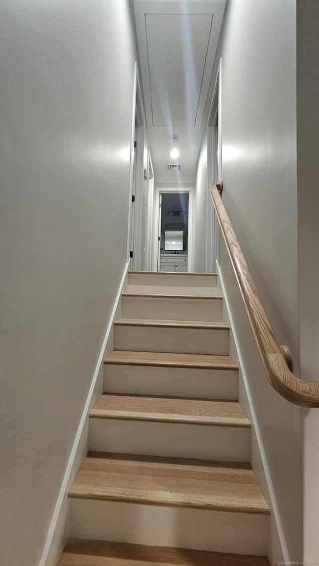 staircase featuring visible vents, baseboards, and attic access