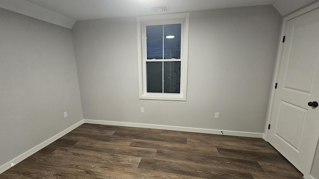 empty room featuring dark wood-type flooring and baseboards