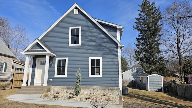 traditional home with an outbuilding, central AC unit, a storage shed, and fence