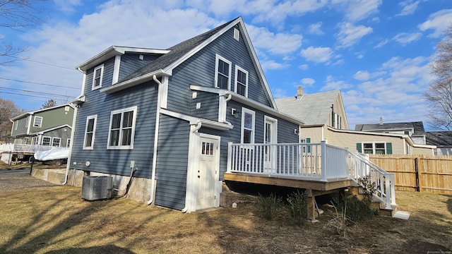 rear view of house with central AC unit, fence, and a wooden deck