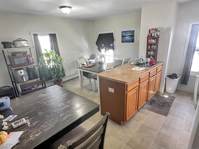 63 Minerva St, Derby, CT 06418 - kitchen with a baseboard heating unit, brown cabinets, a peninsula, and light countertops