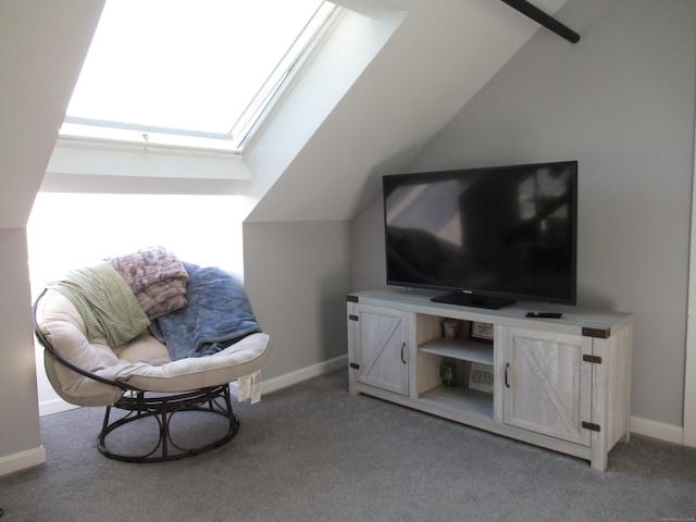 sitting room featuring lofted ceiling with skylight, carpet flooring, and baseboards