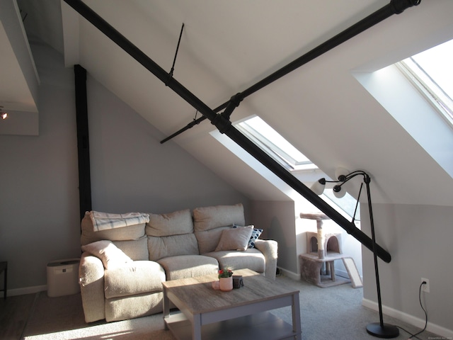 living area featuring vaulted ceiling with skylight, carpet flooring, and baseboards