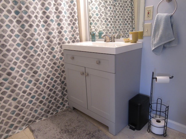 bathroom featuring tile patterned flooring, curtained shower, vanity, and baseboards