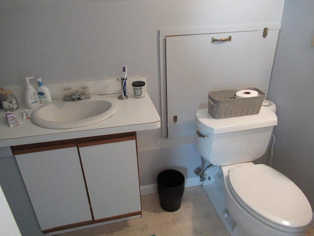 half bath with vanity, toilet, and baseboards