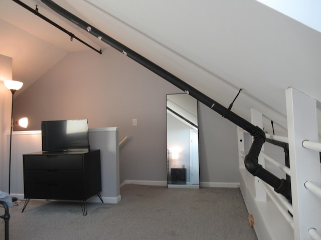 interior space featuring lofted ceiling, baseboards, and carpet floors