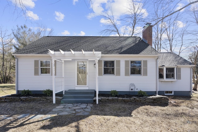 view of front of property featuring a chimney and a shingled roof