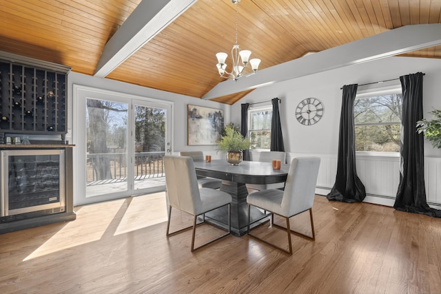 dining area with a wealth of natural light, wine cooler, wood finished floors, and vaulted ceiling