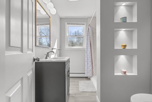 bathroom featuring a shower with curtain, toilet, a baseboard radiator, baseboards, and vanity