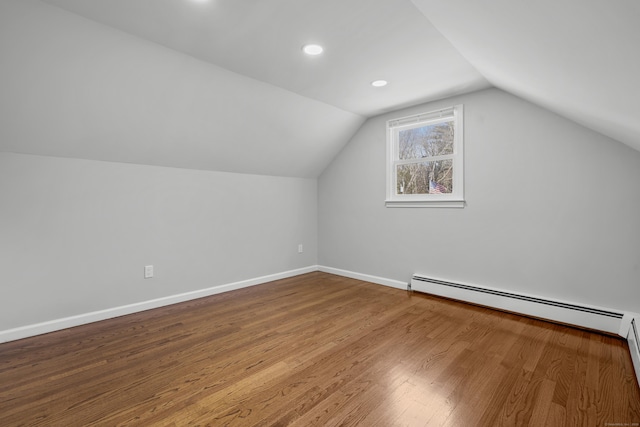 bonus room featuring a baseboard heating unit, baseboards, lofted ceiling, recessed lighting, and wood finished floors