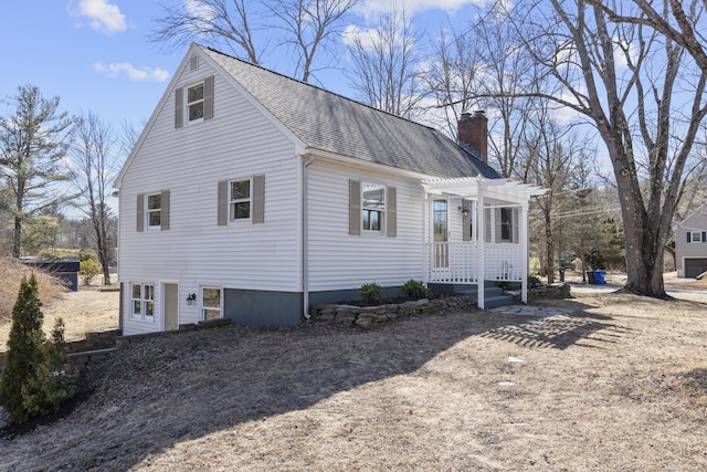 view of front facade with roof with shingles, a chimney, and a pergola