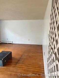 interior space featuring baseboard heating and wood finished floors
