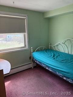 carpeted bedroom with a baseboard heating unit