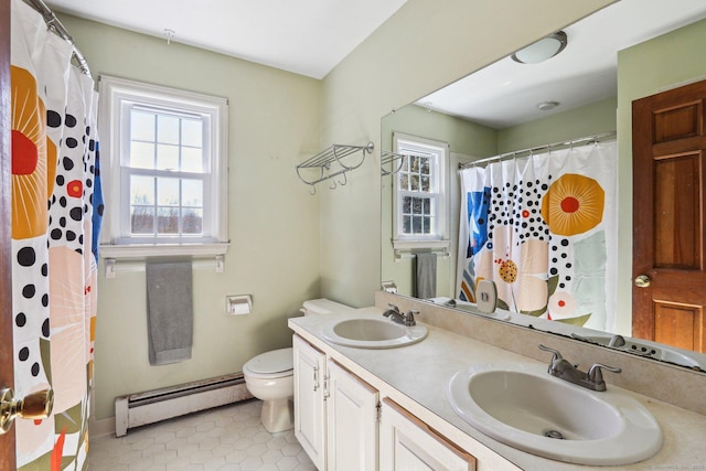 bathroom with double vanity, toilet, a baseboard heating unit, and a sink