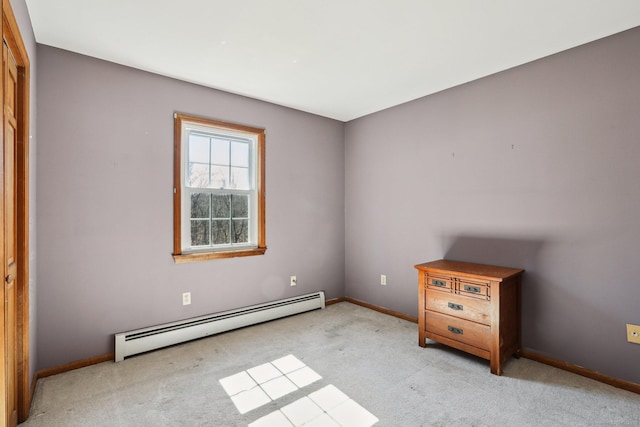 unfurnished bedroom with light colored carpet, a baseboard heating unit, and baseboards