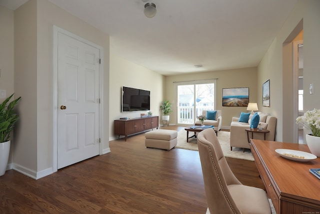 living room featuring visible vents, baseboards, and dark wood finished floors