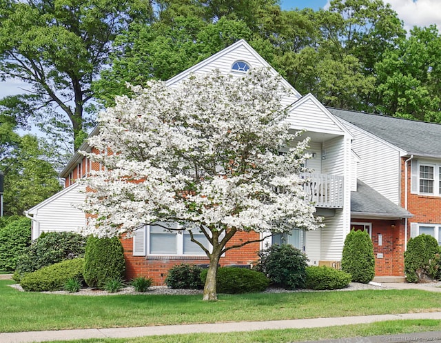 view of front of home featuring brick siding and a front yard