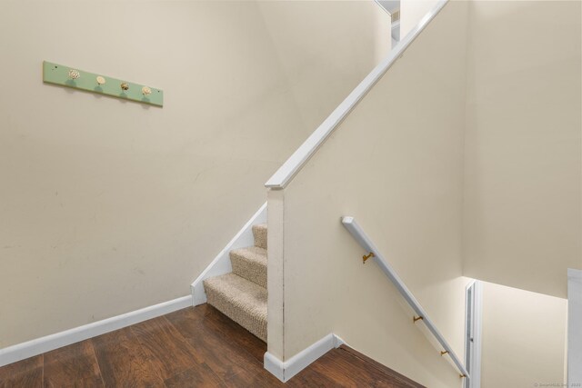 staircase with wood finished floors and baseboards
