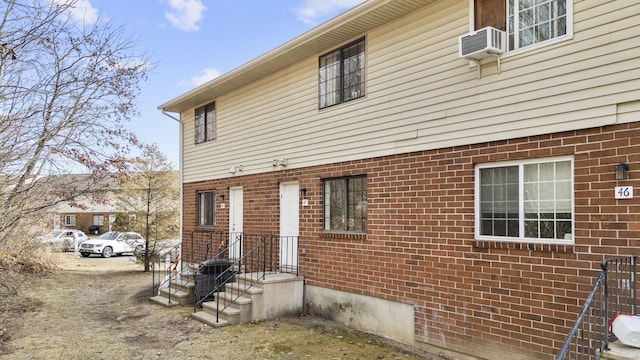 view of property exterior featuring brick siding, central AC unit, and cooling unit