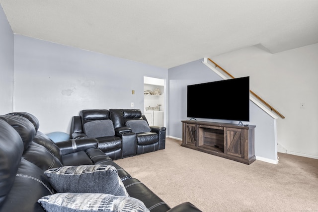 carpeted living area with stairway and baseboards