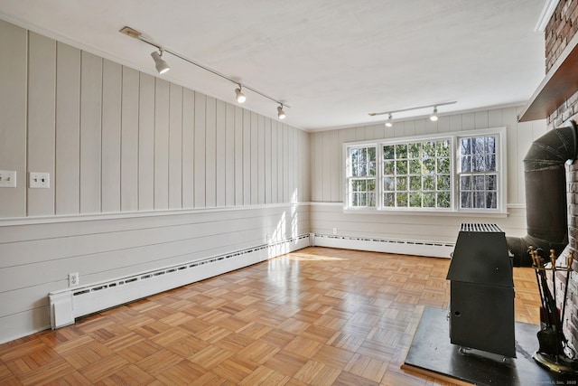 unfurnished living room with a baseboard heating unit and track lighting