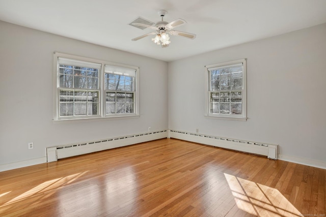 unfurnished room featuring a healthy amount of sunlight, a baseboard radiator, a ceiling fan, and hardwood / wood-style floors