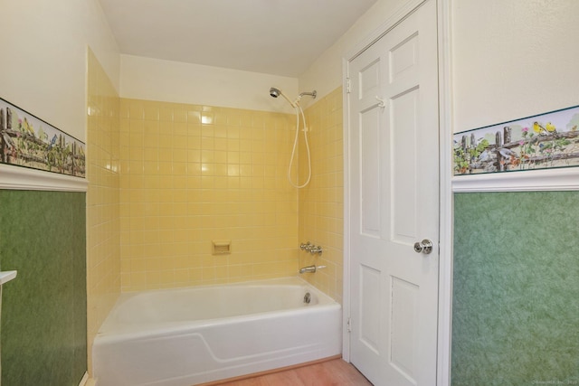 full bath featuring wood finished floors and washtub / shower combination