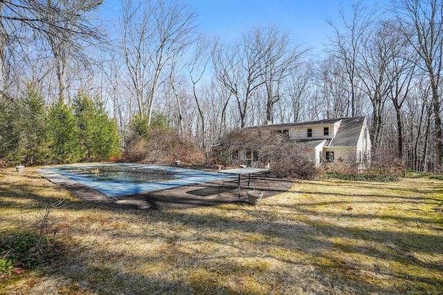 view of pool with a lawn and a diving board