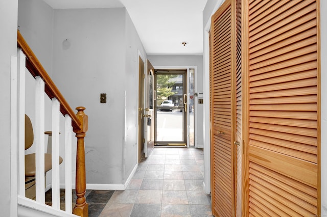 hall with tile patterned floors, stairway, and baseboards