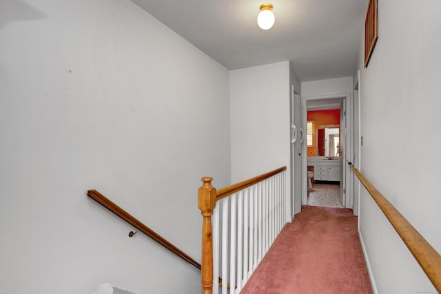 corridor featuring carpet floors and an upstairs landing