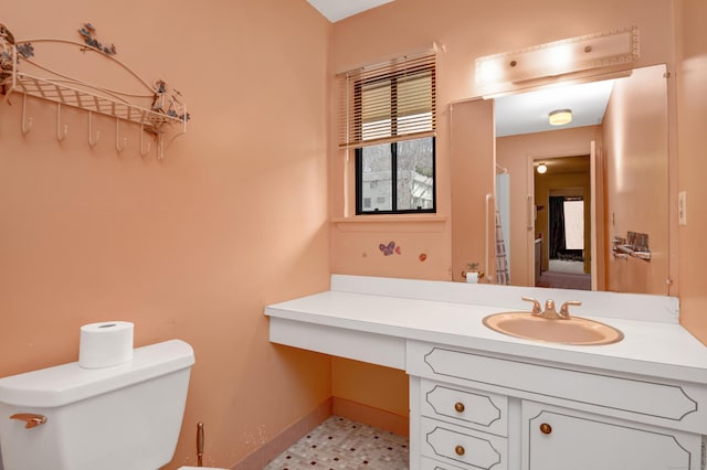 bathroom featuring baseboards, toilet, and vanity