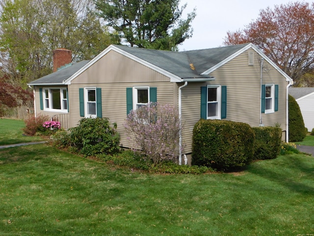 view of home's exterior with a chimney, a yard, and a shingled roof