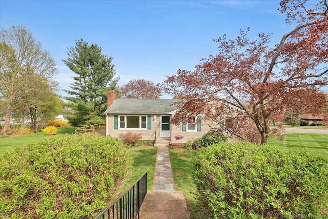 bungalow with a front lawn and a chimney