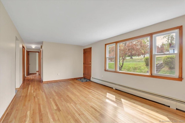 unfurnished living room featuring baseboards, light wood-type flooring, and a baseboard radiator