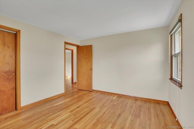 empty room featuring baseboards and light wood-style flooring
