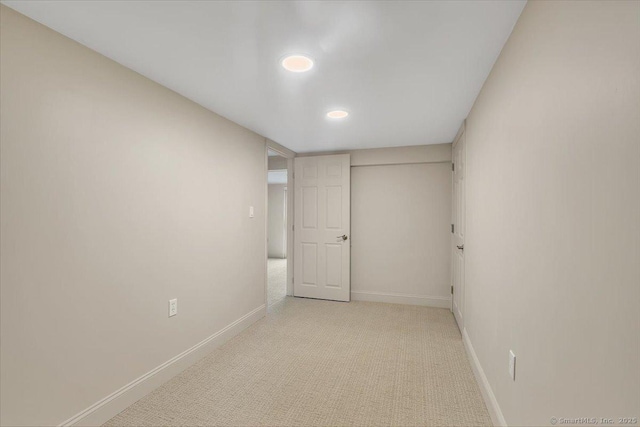 finished below grade area with baseboards, recessed lighting, and light colored carpet