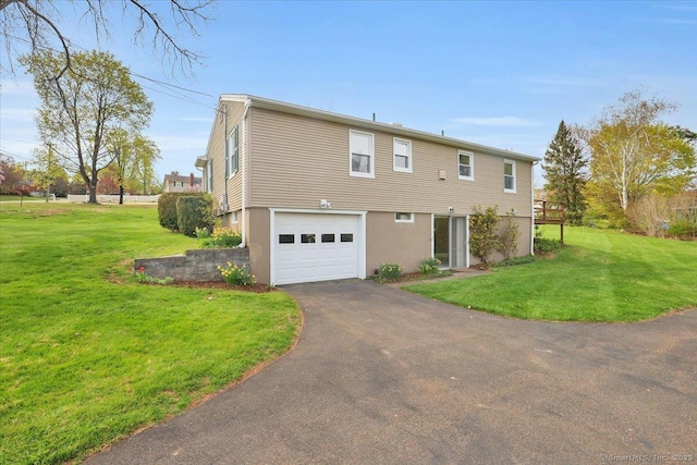 exterior space with a lawn, stucco siding, driveway, and an attached garage