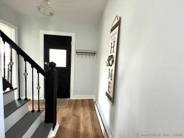 entryway with stairway, plenty of natural light, baseboards, and wood finished floors